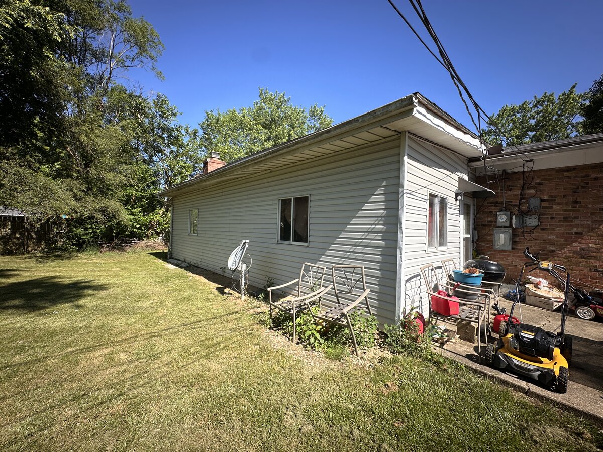 Westerville OH rental home before — cluttered backyard and worn exterior